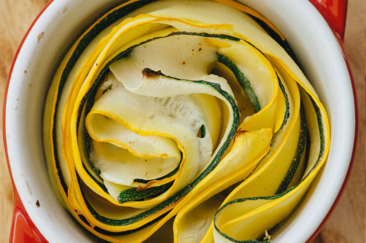 Vegetarisches Gericht mit Corquetten, kunstvoll geschichtet in einer roten Auflaufform