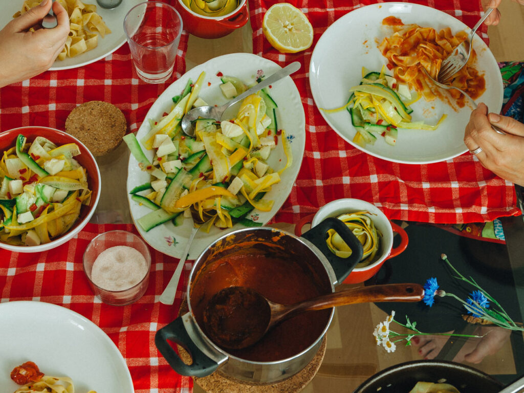 Familientisch mit Pasta und Zucchinisalat